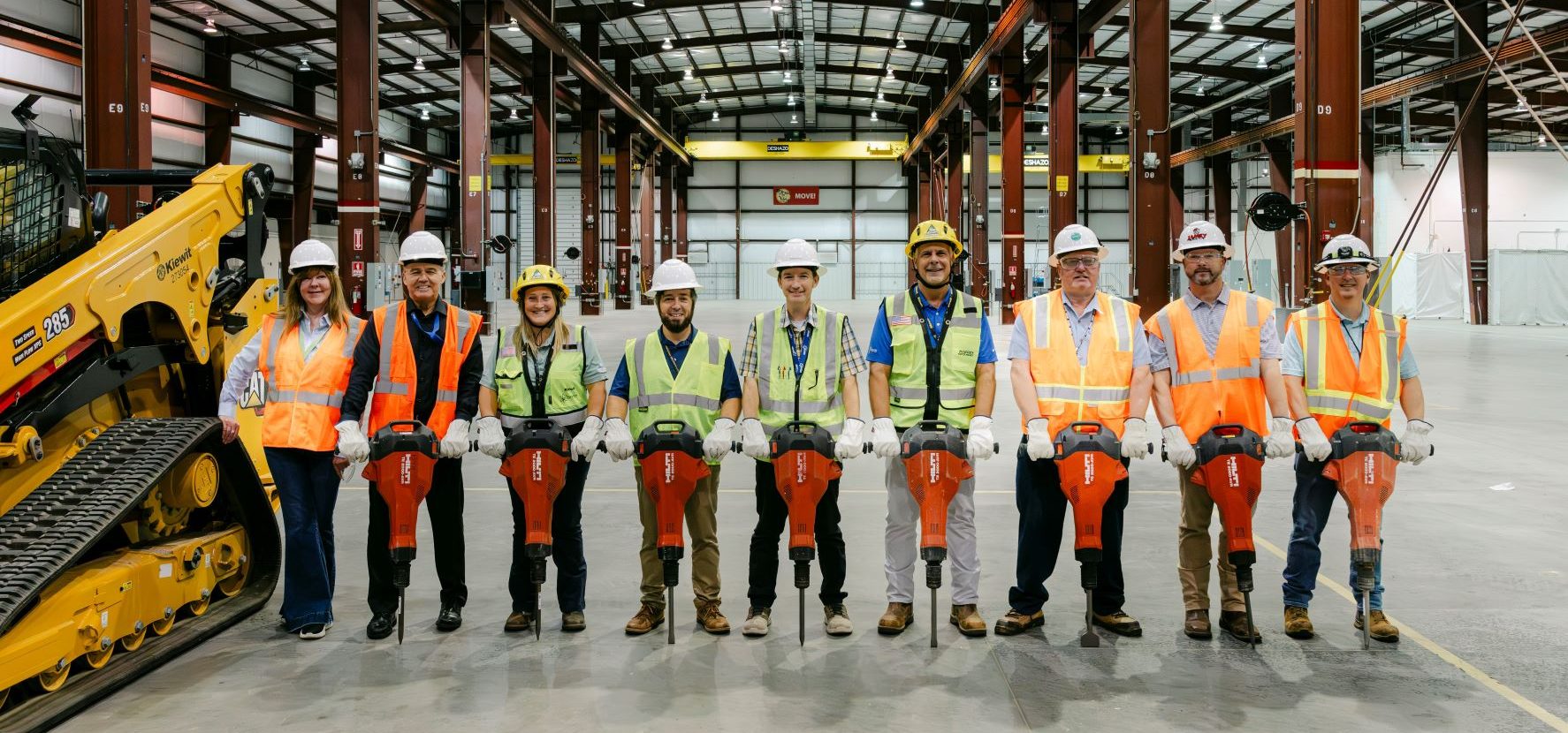SRNS identified subcontractor Kiewit to kick off the early construction scope for the High-Fidelity Training and Operations Center (HFTOC) subproject. Representatives from SRNS and Kiewit are pictured with jackhammers inside the existing HFTOC structure as the initial scope will include replacement of the concrete flooring and other external and internal building modifications.