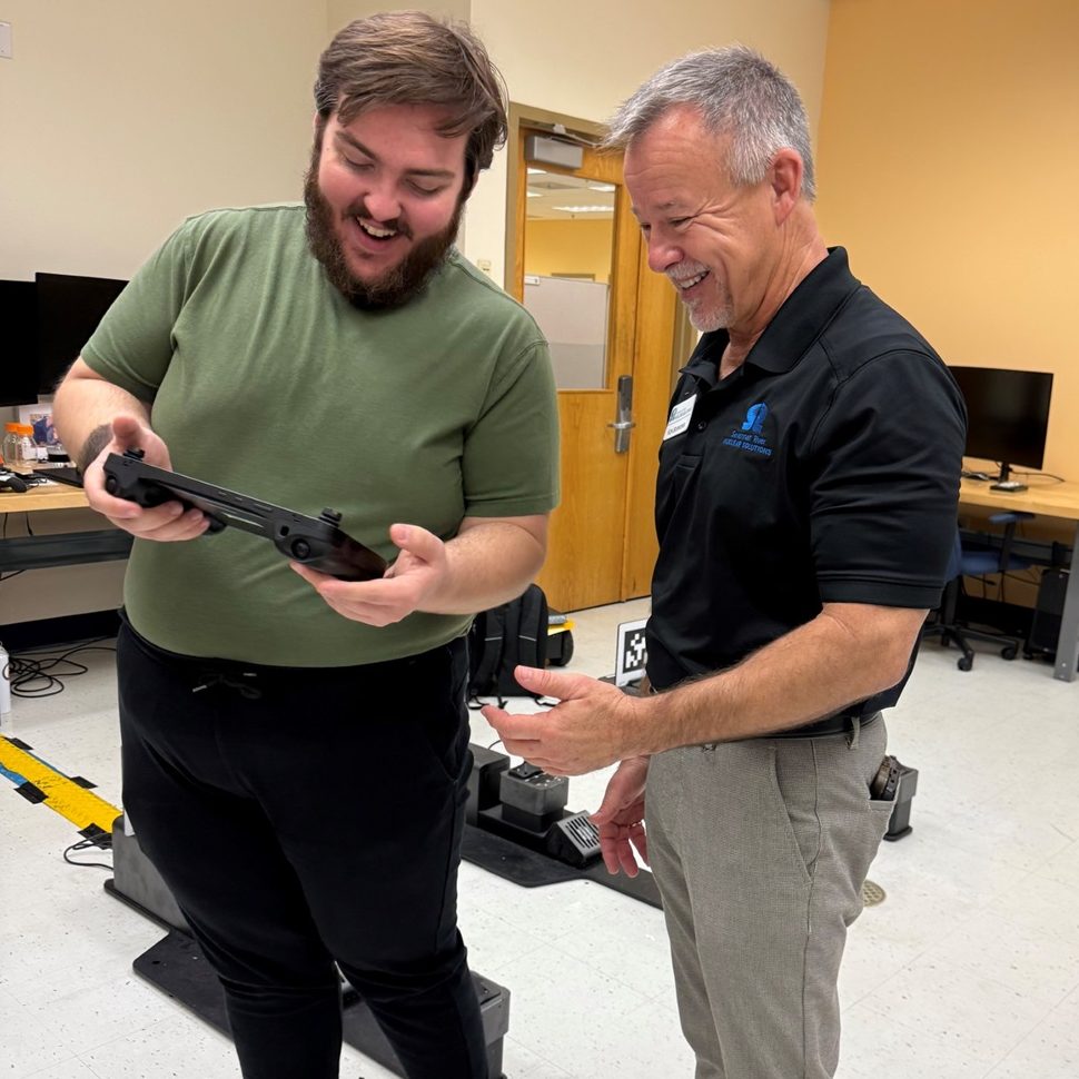 DOE Fellows Program Mechanical Engineer Brendon Cintas, left, and SRNS Director of Engineering Technical Services Ken Burrows, right, test out the Boston Dynamics Robot nicknamed ‘Spot,’ showcasing cutting-edge technology being integrated into DOE projects.