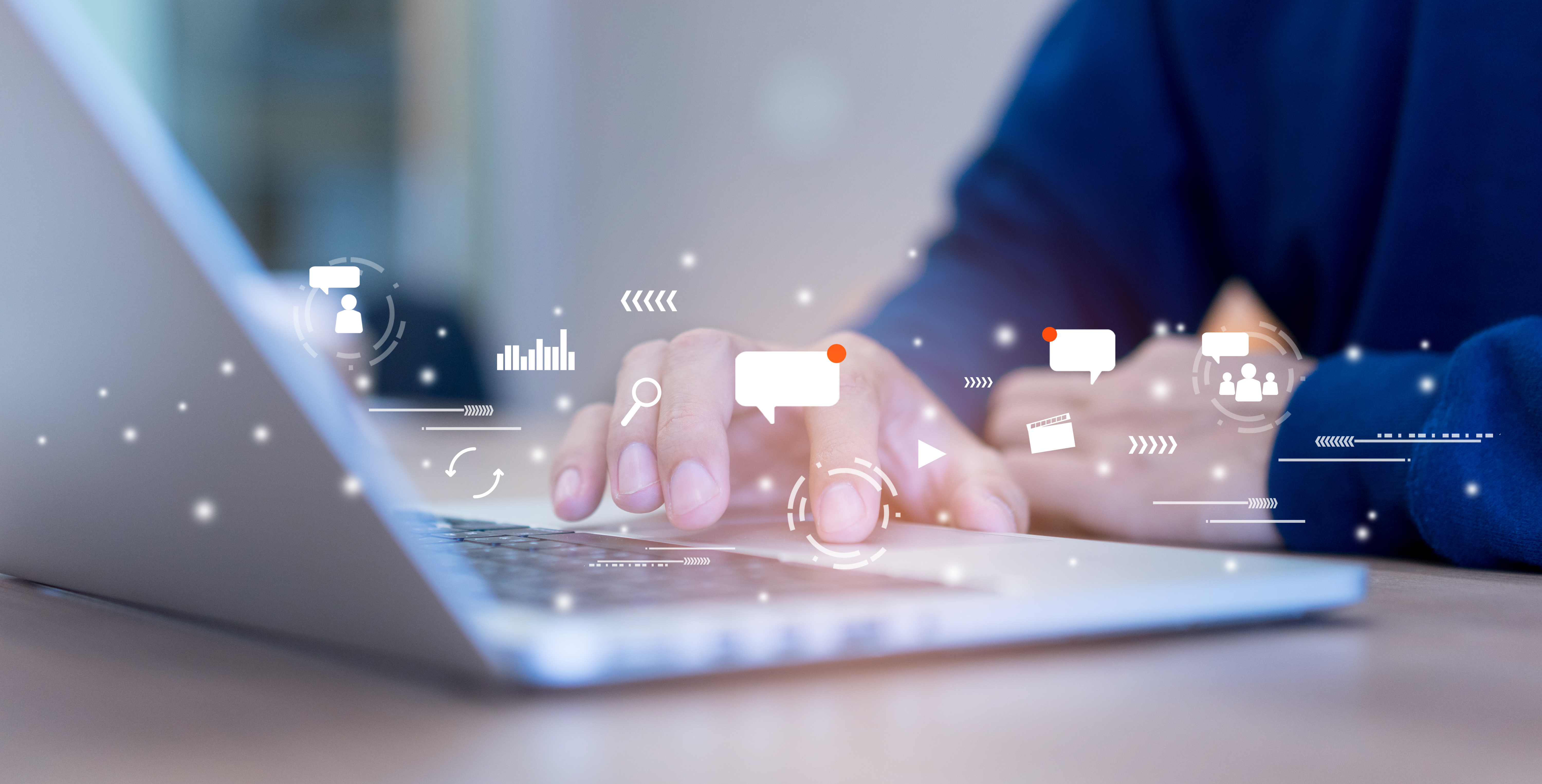 Image of person using laptop with social media icons superimposed above the keyboard.