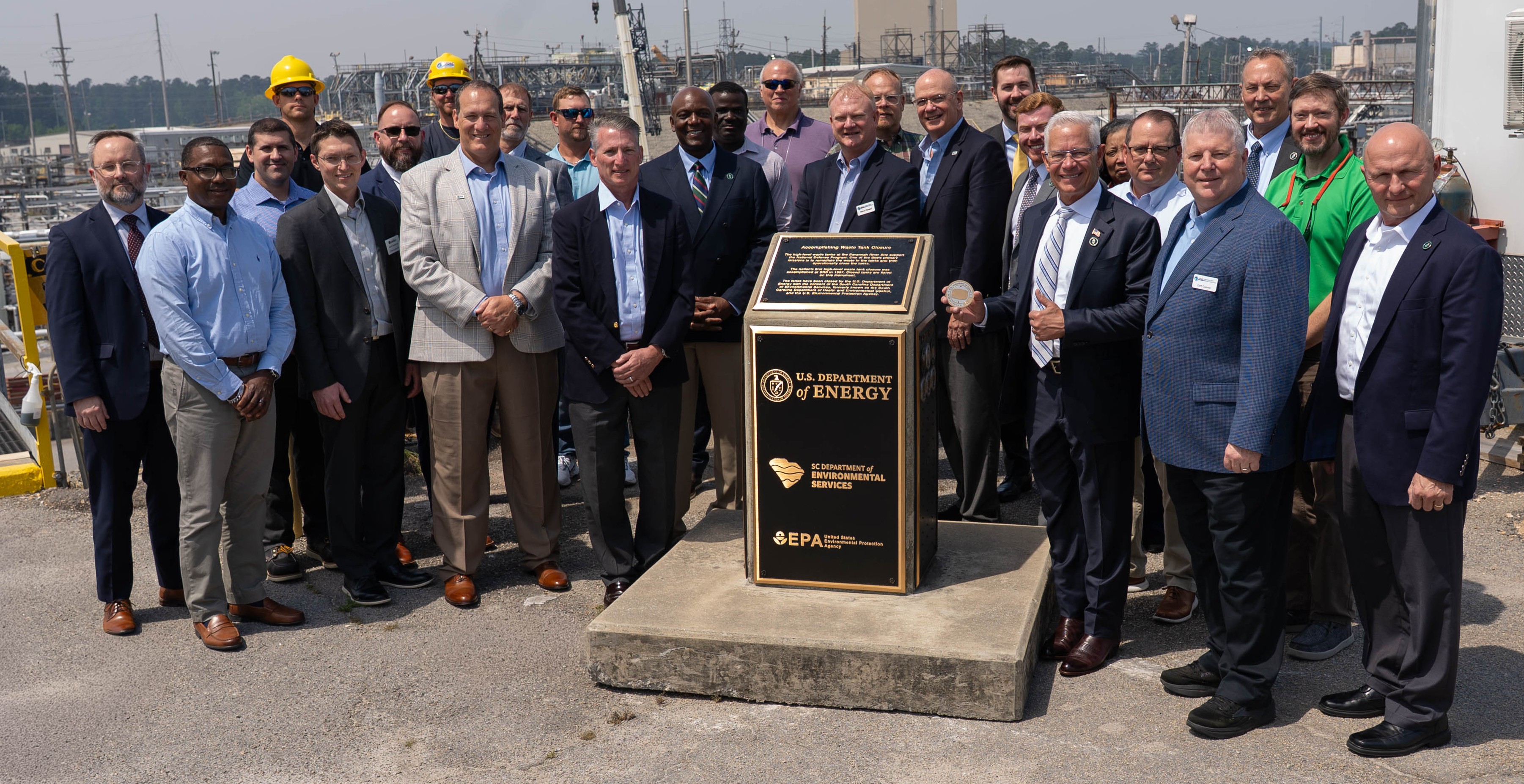 Assistant Secretary of Environmental Management (EM) Tim Walsh (right of monument) and EM Principal Deputy Assistant Secretary Joel Bradburne (right, back row) joined senior managers from the Department of Energy Savannah River Operations Office and Savannah River Mission Completion and other personnel who contributed to the milestone to commemorate Tank 14 reaching preliminary cease waste removal.